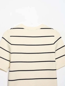 Detail of cream knit top with black horizontal stripes and a classic round neckline