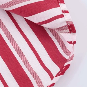 Detailed close-up of red and white striped fabric with professional stitching on the hem