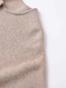 Detail of soft camel knit texture with round collar and fine stitching on the cardigan