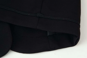 Close-up of black jacket cuff with horizontal ribbed texture and braided rope edge detail