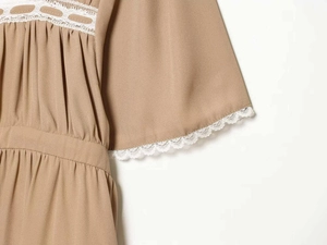 Détail de la robe kaki avec dentelle blanche, manches évasées et texture plissée fine
