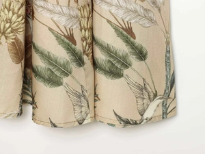 Detail of floral printed dress featuring tropical green leaves and hummingbird patterns