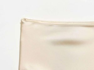 Macro detail of champagne satin skirt featuring delicate lace hem and stitching