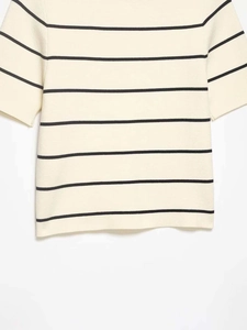 Close-up of beige knit top featuring horizontal black stripes and high-density texture