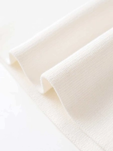 Close-up of high-quality white knitted fabric with fine ribbed texture and soft feel