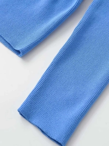 Detailed macro view of the bright blue ribbed knit texture and accordion sleeve stitching