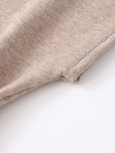 Close-up of knit fabric texture in oatmeal beige with detailed edge stitching