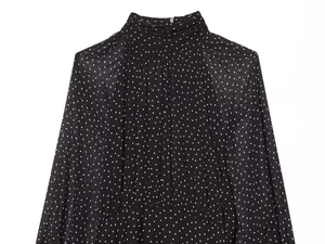 Detail of high collar pleated neckline on a black and white polka dot chiffon dress