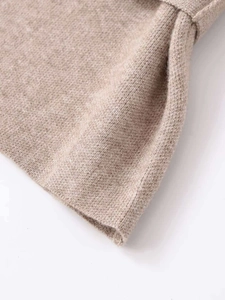 Close-up macro of premium oat-brown knitted fabric showing soft wool texture and fine stitching