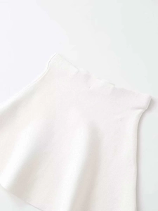 Detail view of high-waist white knitted A-line skirt with subtle textured fabric finish