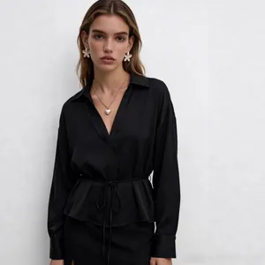 Detailed view of women's black satin shirt featuring a classic collar and matching waist belt