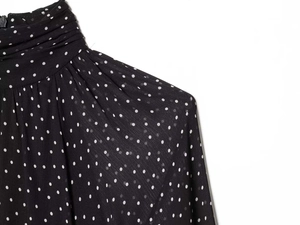 Detail of high neck pleated collar on polka dot chiffon dress with rear zipper closure