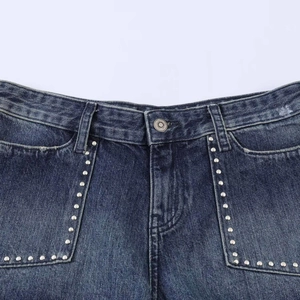 Pantaloncini di jeans blu scuro con borchie argentate e bottone in metallo su bianco