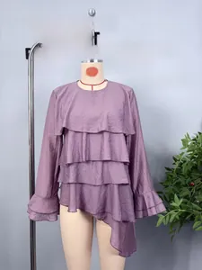 Detailed close-up of layered purple chiffon ruffles and asymmetric hem on long sleeve top