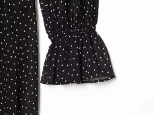 Close-up of elastic ruffled cuffs and polka dot chiffon fabric on the dress sleeve