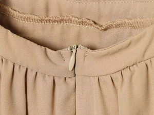 Gros plan sur la fermeture éclair invisible et les plis de la robe en dentelle kaki