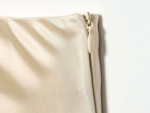 Macro shot of seamless invisible zipper on elegant cream satin fabric with silk texture