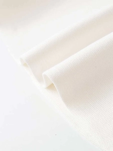 Close-up of white knit fabric texture showing fine weave and soft material detail
