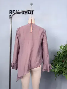 Detail of mauve asymmetric hem top with ruffled bell sleeves and back teardrop cutout
