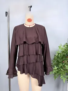Detail of dark brown tiered ruffles and asymmetric layered texture on long sleeve top