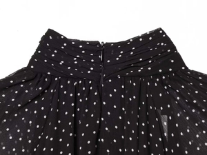 Detail of invisible zipper and pleated chiffon fabric with white polka dots on black