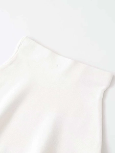 Detailed close-up of the white high-waisted knit skirt with fine textured fabric weave