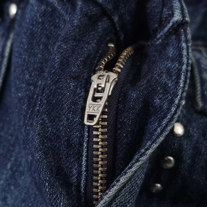 Dettaglio degli shorts in denim blu scuro con cerniera YKK e borchie metalliche argentate
