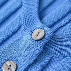 Bright blue knit cardigan with accordion sleeves and iridescent mother-of-pearl buttons
