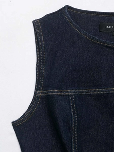 Detailed close-up of dark blue denim vest featuring contrast yellow double stitching