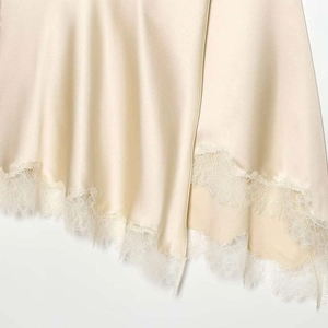Elegant champagne satin midi skirt featuring delicate white lace trim and an asymmetric hem