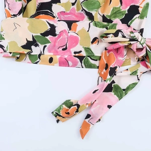 Dettaglio ravvicinato del tessuto in chiffon floreale astratto con nodo laterale decorativo
