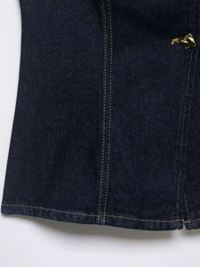 Detail view of dark blue denim vest with contrast yellow stitching and metal button