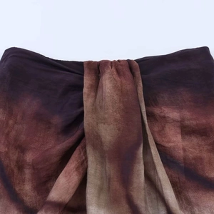Detailed macro view of gradient dye fabric with intricate pleated layering design