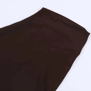 Close-up of the smooth dark brown plain weave fabric and neat stitching on dress hem