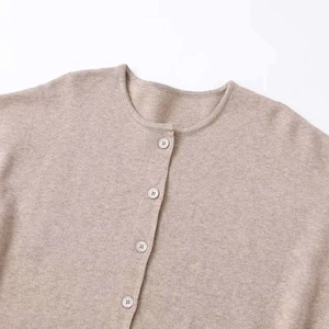 Minimalist beige round-neck knit cardigan with classic white buttons for a soft visual look