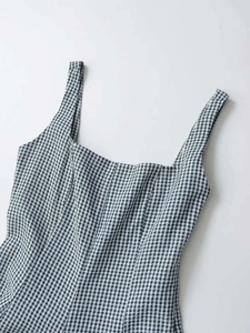 Détail de l'encolure carrée et des larges bretelles sur une robe vichy noir et blanc