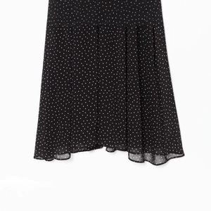 Polka dot pleated chiffon dress in black and white with an elegant wavy hemline