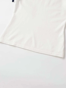 Close-up of the knitted fabric texture and neat hem stitching on a white short sleeve top