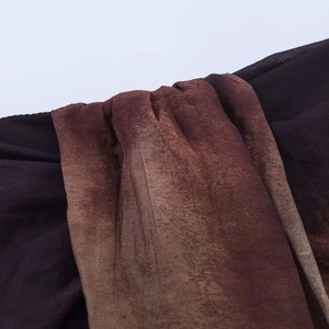 Detailed close-up of dark purple and brown gradient fabric with fine texture and soft folds