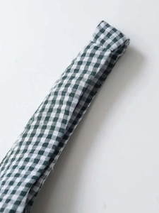 Détail du tissu vichy vert et blanc montrant la texture de coton tissé de haute qualité
