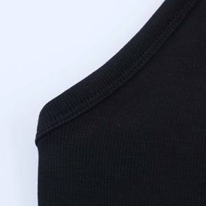 Close-up of black rib-knit fabric texture and stitching details of the bodysuit strap