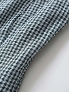 Détail de la texture du tissu vichy vert et blanc pour robe midi d'été textile