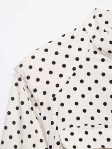 Détail du chemisier rétro à pois avec col montant et texture douce en tissu mélangé