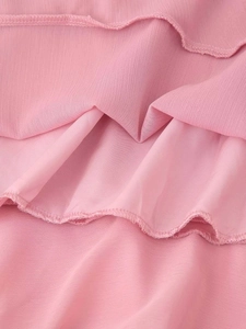 Dettaglio dei volant a strati in chiffon rosa con cuciture rifinite e precise
