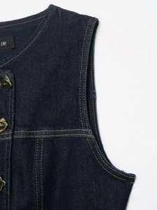 Detailed view of dark blue denim vest with contrast stitching and gold metal buttons