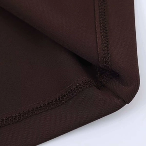 Detail of clean overlock stitching on the edge of a dark brown short sleeve dress