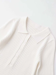 Nahaufnahme eines weißen Rippstrick-Poloshirts mit feiner Textur und Knopfleiste