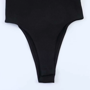 Detail of black ribbed knit bodysuit showing high-cut leg and fine hem stitching quality