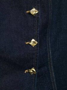 Detail of dark blue denim vest with textured fabric and three gold geometric buttons