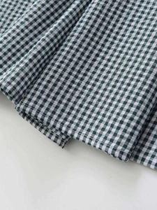Détail du tissu à carreaux vichy vert et blanc avec une finition de couture plate